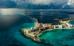 A rainstorm approaches hotels in Cancún, near Puerto Morelos, Mexico, on Nov. 15, 2020. In an unusual experiment, a coral reef in Mexico is now insur