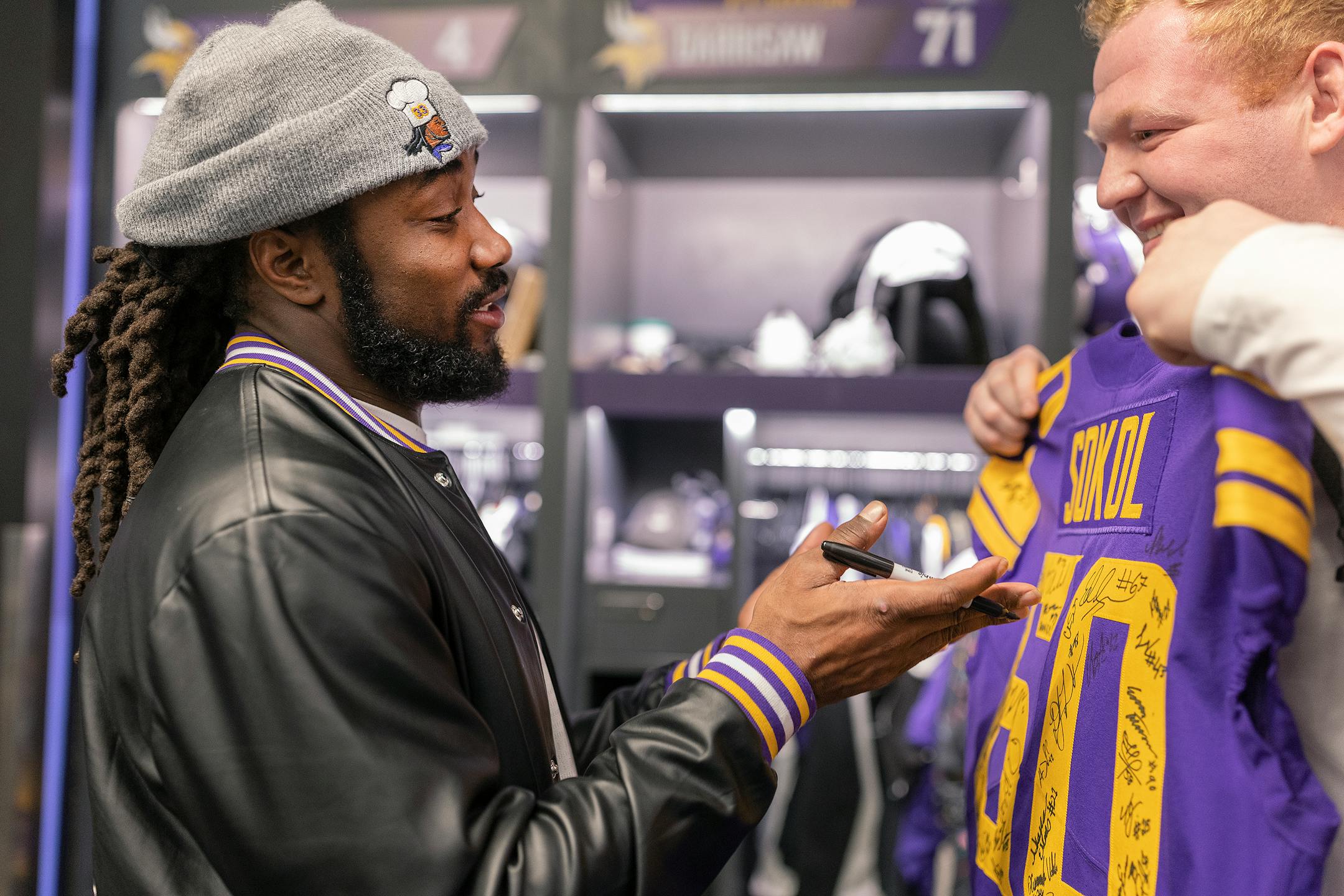 Minnesota Vikings running back Dalvin Cook (4) signs a jersey for Minnesota Vikings center Josh Sokol (60) at the TCO Performance Center.