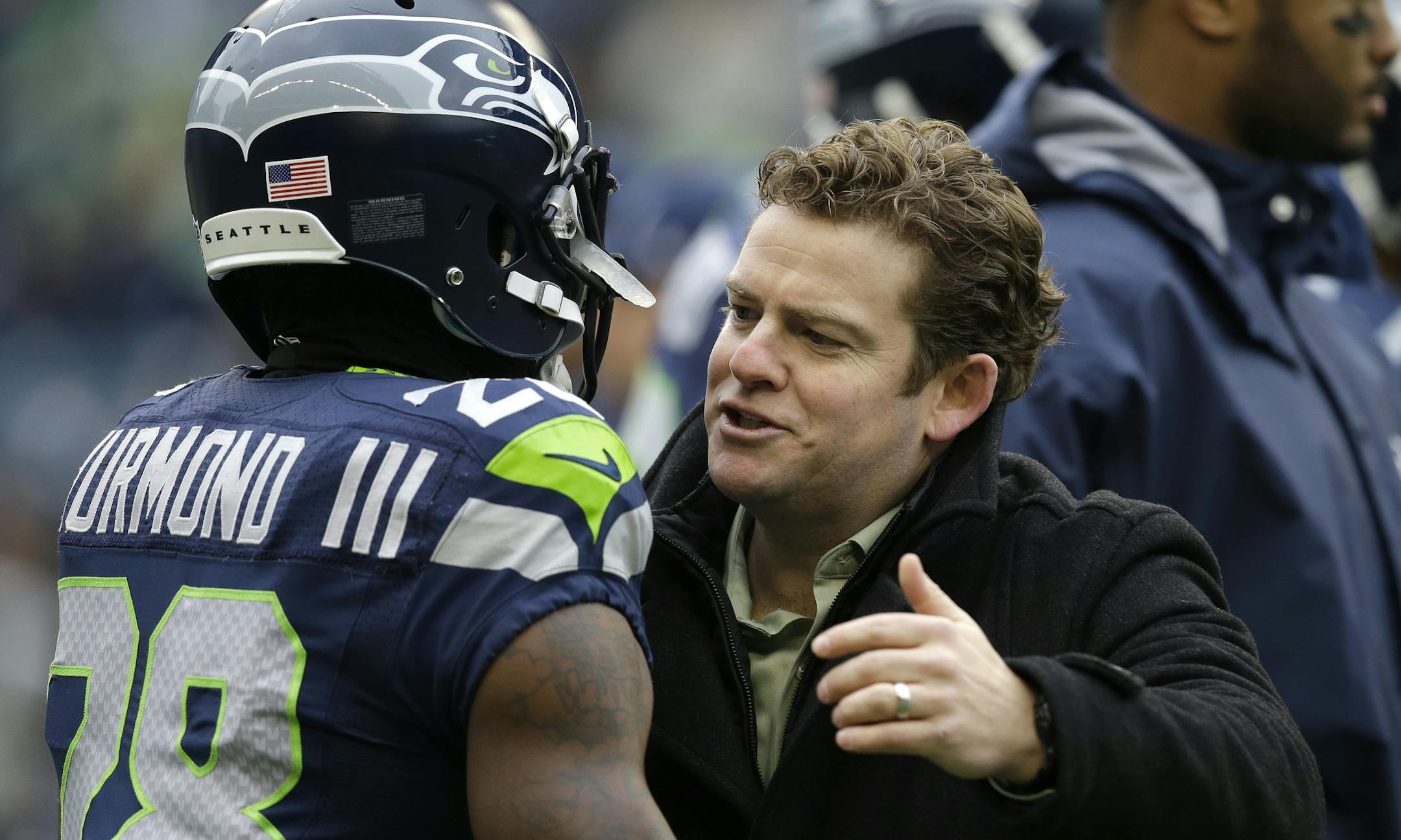 Seattle Seahawks cornerback Walter Thurmond, left, is greeted by Seahawks general manager John Schneider on the field before an NFL football game against the St. Louis Rams, Sunday, Dec. 29, 2013, in Seattle. (AP Photo/Elaine Thompson) ORG XMIT: MIN2014012919212043