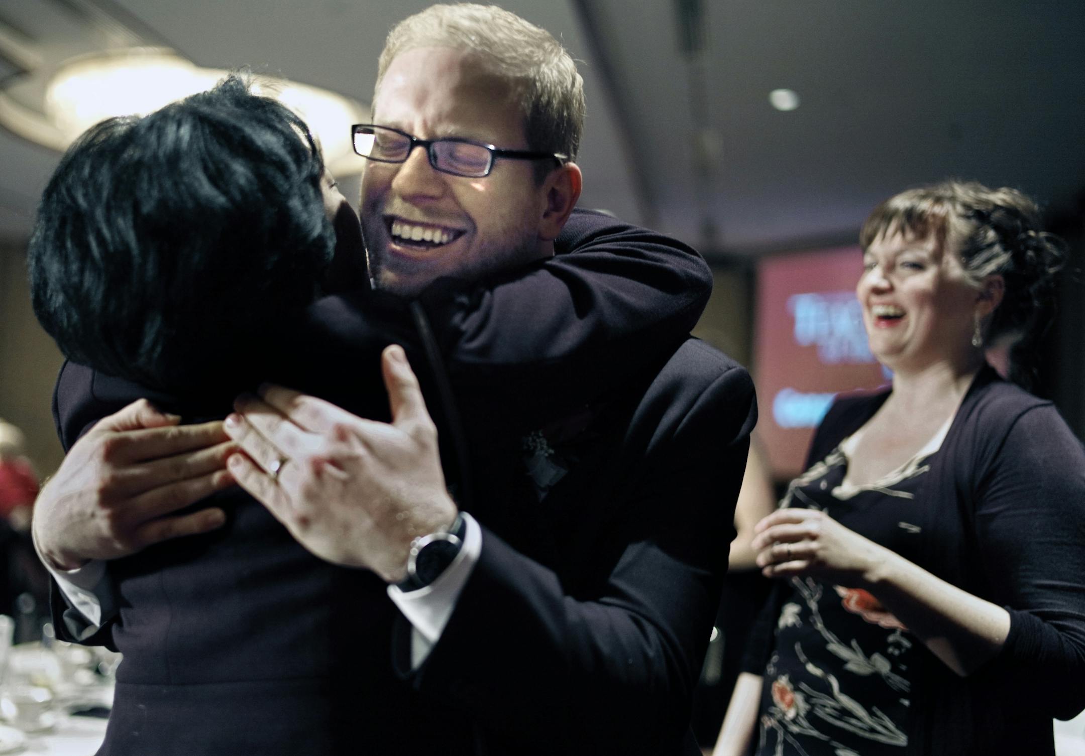 Thomas Rademacher, an English teacher at the FAIR School in the West Metro Education Program, celebrated his MInnesota Teacher of the year award with a hug from past 2006 winner Lee-Ann Stephens of St. Louis Park. His wife Laura is in the background.