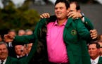 Former Masters champion Sergio Garcia helps Patrick Reed with his green jacket after winning the Masters