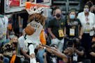 Milwaukee Bucks forward Giannis Antetokounmpo, top, dunks over Phoenix Suns guard Chris Paul during the second half of Game 5 of basketball's NBA Fina