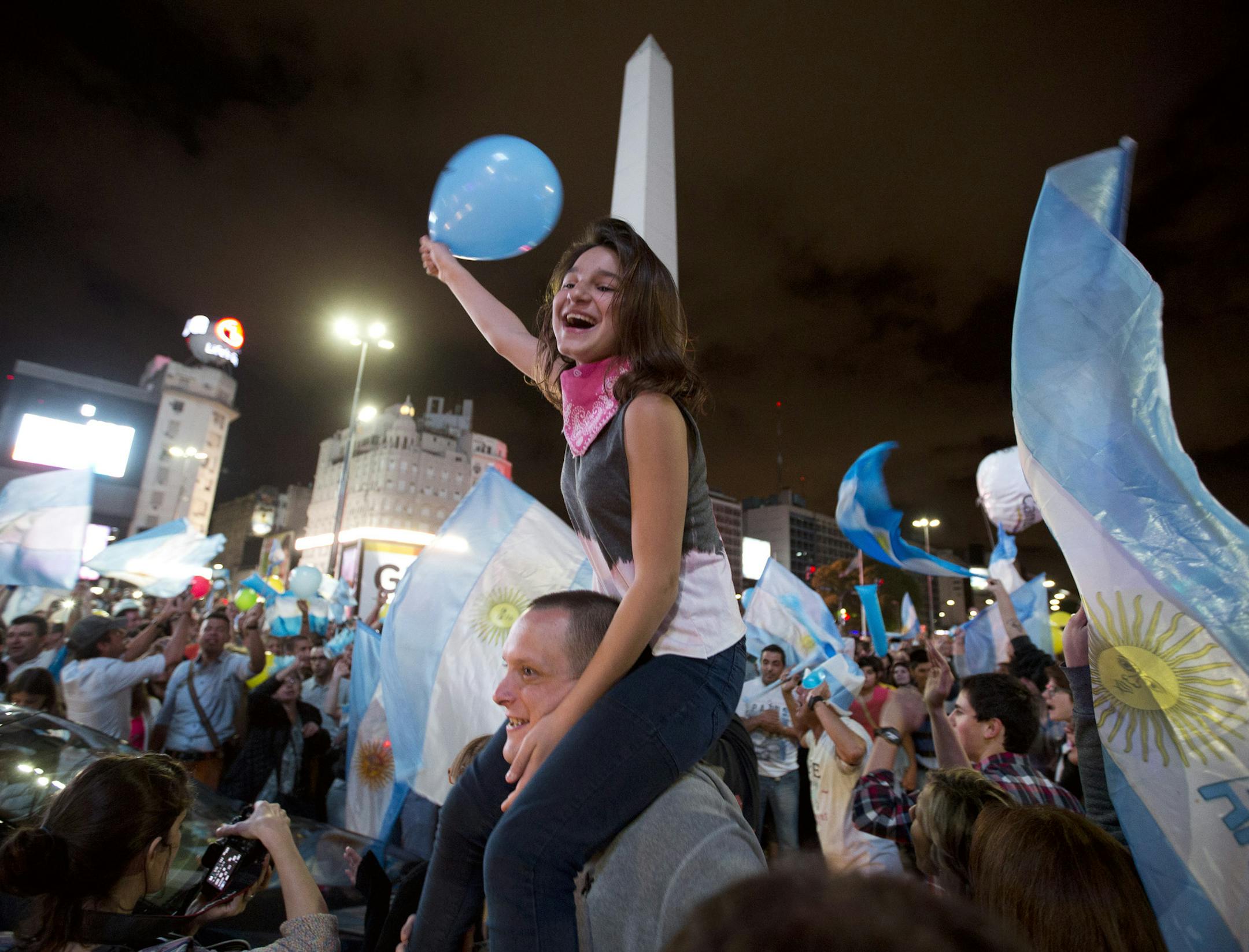 Supporters of presidential candidate Mauricio Macri celebrate at the Obelisk plaza in Buenos Aires, Sunday, Nov. 22, 2015. Macri won Argentina's historic runoff election against ruling party candidate Daniel Scioli, putting an end to the era of President Cristina Fernandez, who along with her late husband dominated Argentine politics for 12 years. (AP Photo/Victor R. Caivano)