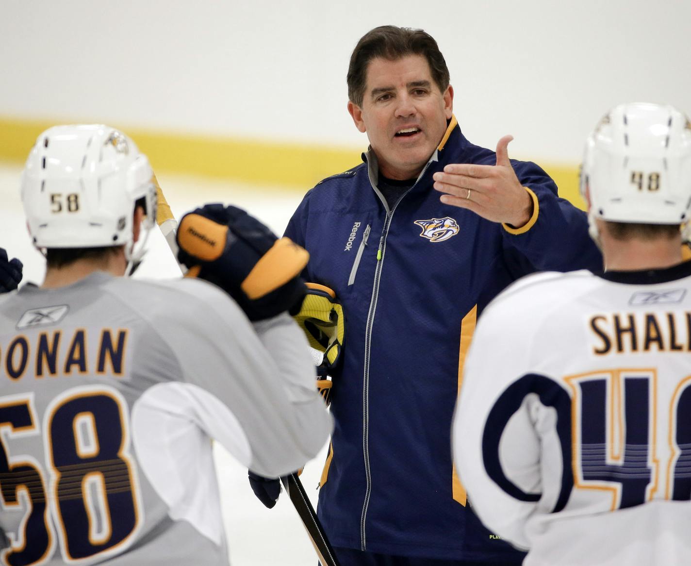 Nashville Predators head coach Peter Laviolette talks with players, including defenseman Garrett Noonan (58) and forward Josh Shalla (48), during NHL hockey training camp, Friday, Sept. 19, 2014, in Nashville, Tenn. (AP Photo/Mark Humphrey) ORG XMIT: TNMH102