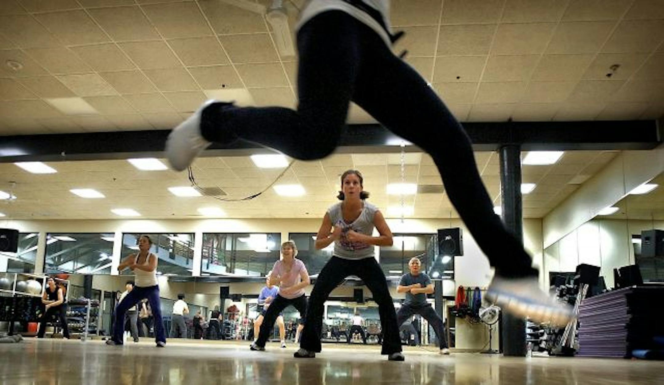 Instructor Lisa Van Ahn framed student Dawn Hudson (center) as she leaped in the air while teaching a mind body class called IntenSati at the Calhoun Beach Club in Minneapolis.