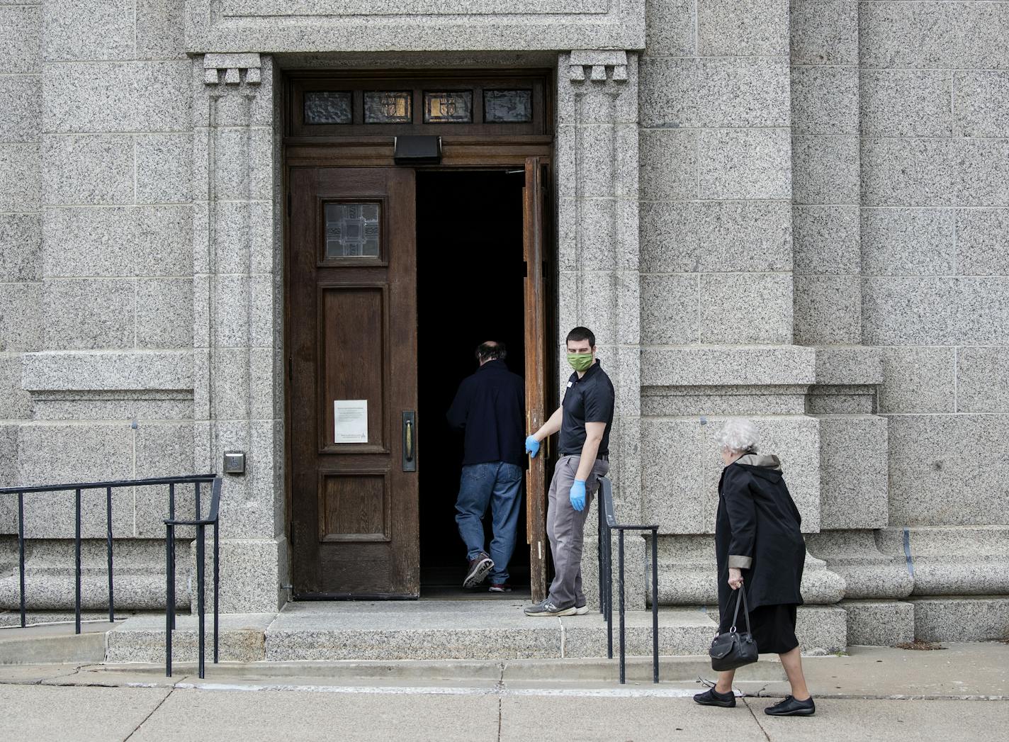 Ben Nelson held the door open for people heading into confession at the St. Paul Cathedral. Nelson works maintenance at the Cathedral. Part of his responsibility include sanitizing and making sure that there are under 10 people inside during confessions. ] CARLOS GONZALEZ • cgonzalez@startribune.com – St. Paul, MN – May 21, 2020, COVID-19, Coronavirus, The St. Paul Cathedral is only open for confessions at this point. You can't just go in. Confession hours are from 3:30 pm to 5 pm, and you need