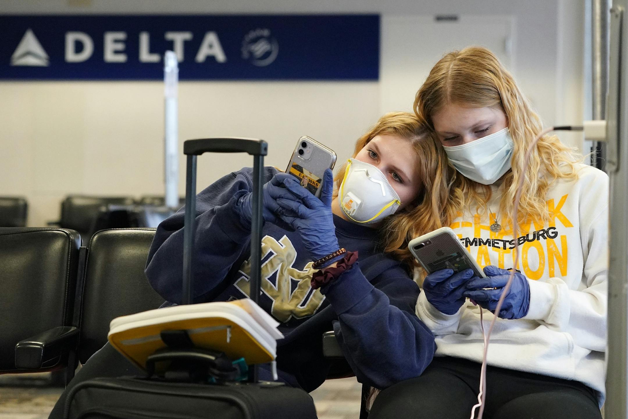 Rachel Miner, 15, left, of Emmetsburg, Iowa sat with Carlotta Haas, 15, right, a German foreign exchange student from Duesseldorf who had been living with her but was called home as they waited for her flight Wednesday at MSP.