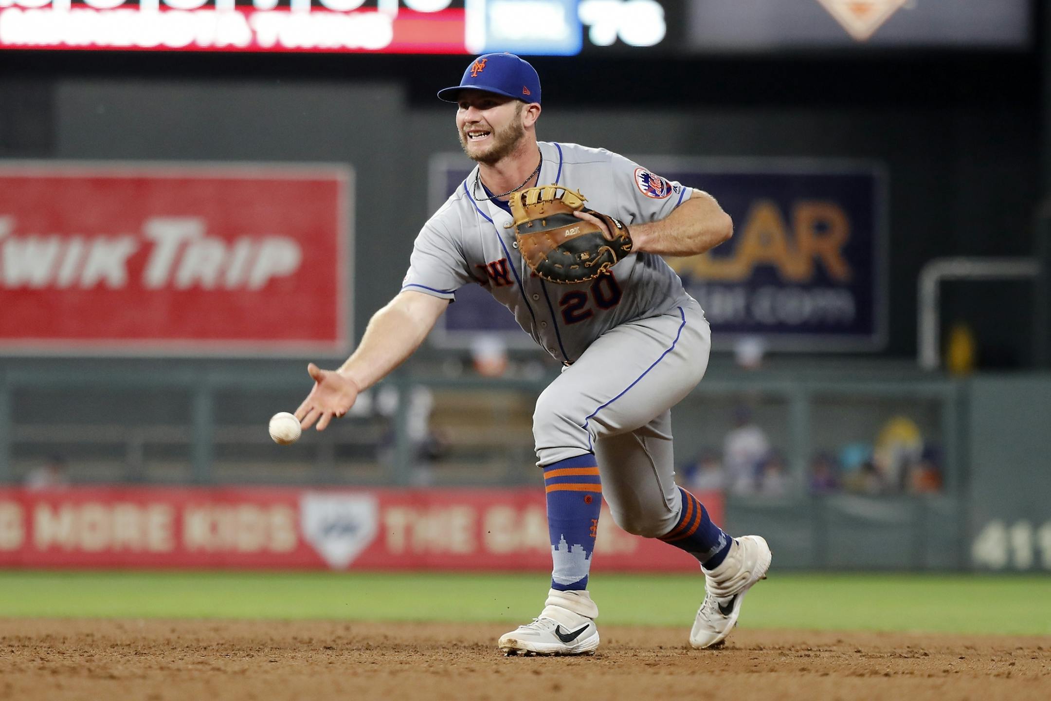 New York Mets first baseman Pete Alonso (20) fields the ball and underhand throws for an out.