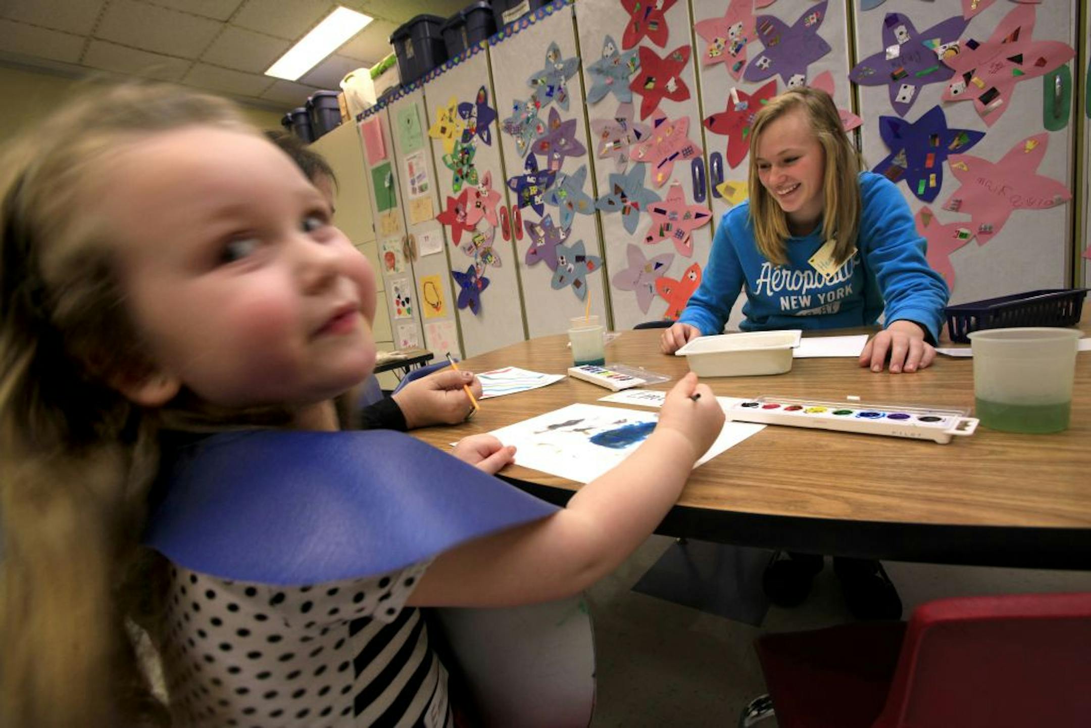 Sophmore student Heaven Leeper works on a painting prject with one of the preshcool children at Blaine High School on December 18, 2012. Sophmore student Heaven Leeper is in the background.