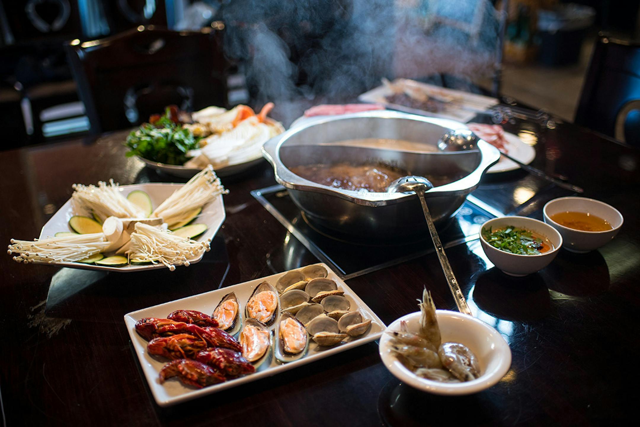 Little Szechuan's Hot Pot with sirloin beef slices, lamb slices, luncheon meat, shrimp, mussels, clams, fish tofu, Chinese cabbage, watercress, yams, winter melon, king oyster mushrooms, enoki mushrooms, wood ear mushrooms, frozen tofu, potato sticks and chicken gizzards.