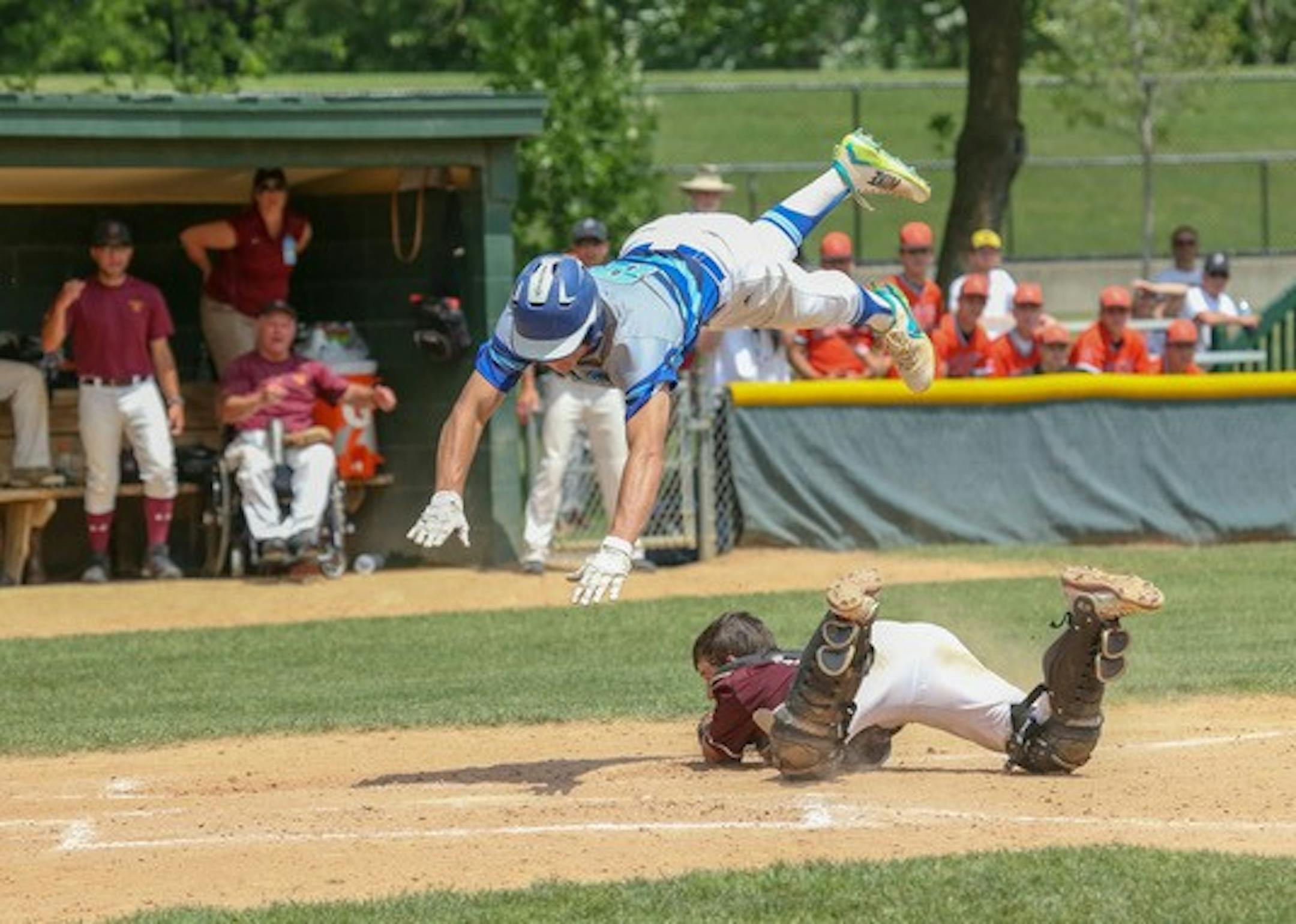 Heritage Christian Academy senior Seth Halvorsen goes airborne to avid the tag of Parkers Prairie catcher Brock Peterson. Despite the athletic play, Halvorson was out for going up and over the catcher. Photo by Jeff Lawler, SportsEngine