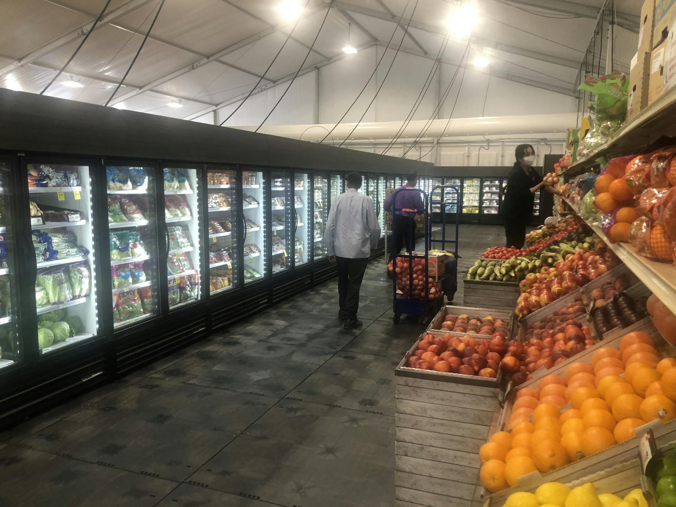 Employees filled shelves with vegetables and fruit at the temporary Cub Foods store in a tent on East Lake Street.
