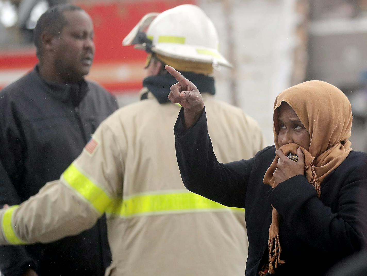 Residents of a south Minneapolis high-rise were evacuated Wednesday after a fire broke out on the 14th floor, killing five. Here, a woman who didn't live in the building pointed up to where the fire was.