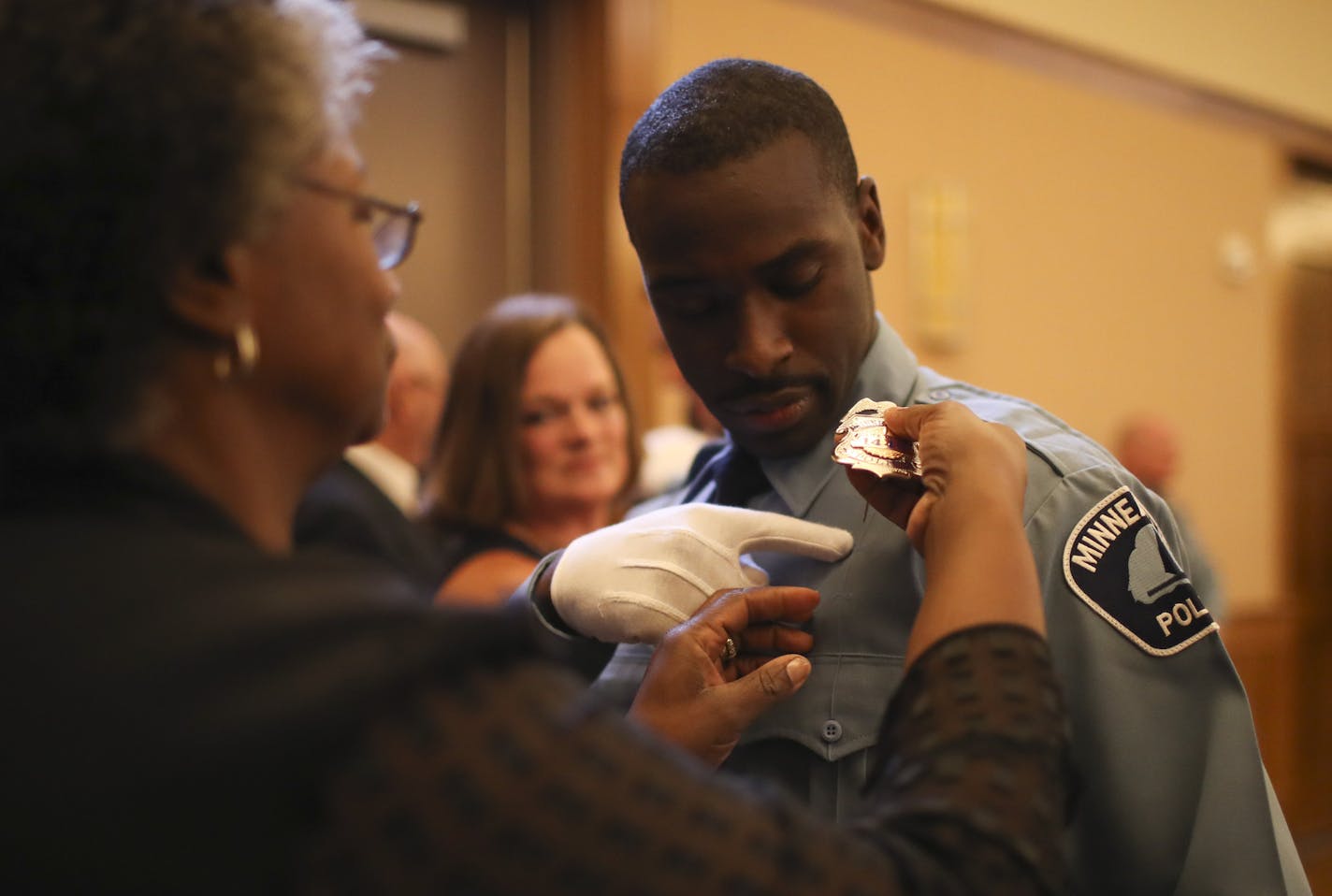 Timothy Davis, Jr. showed his mother, Clarissa Davis, where to pin his Minneapolis Police Department badge before he took the oath of office with the other members of the class Wednesday evening. ] JEFF WHEELER &#xef; jeff.wheeler@startribune.com Eight new members of the Minneapolis Police Department were sworn in Wednesday evening, June 1, 2016 in a ceremony at St. Mary's Greek Orthodox Church. In addition, two Park Police officers were sworn in, too. All were already city employees before atte