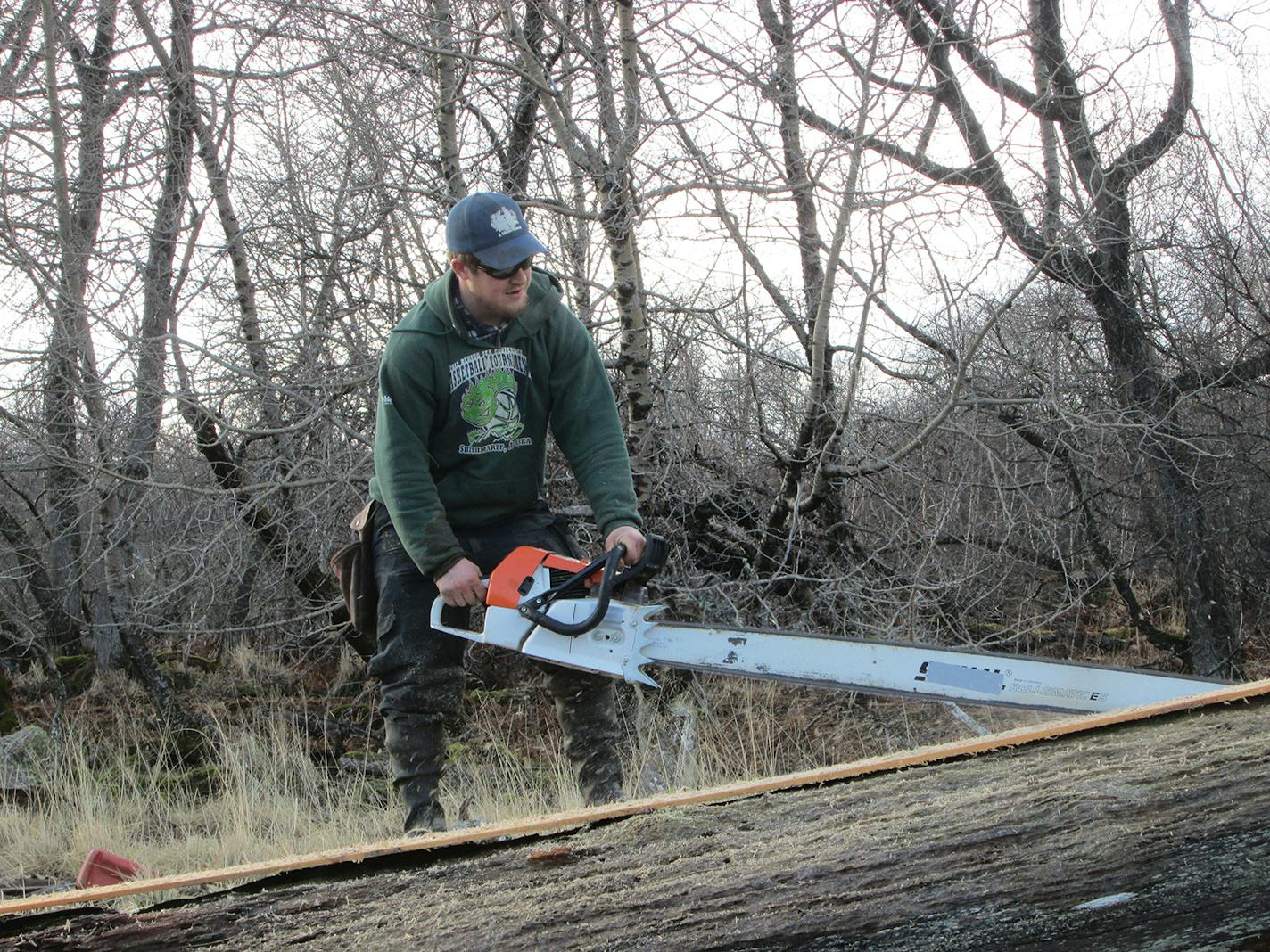 At the build site in Larsen Bay, Blanco sawed a huge piece of driftwood before milling it.