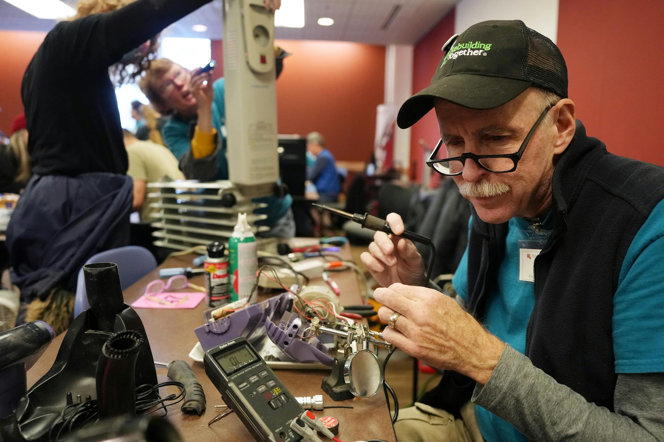 Bill Berschneider solder together wires in a vacuum during a Ramsey County fix-it clinic Saturday, Nov. 19, 2022 at the Ramsey County Library in Maplewood, Minn.