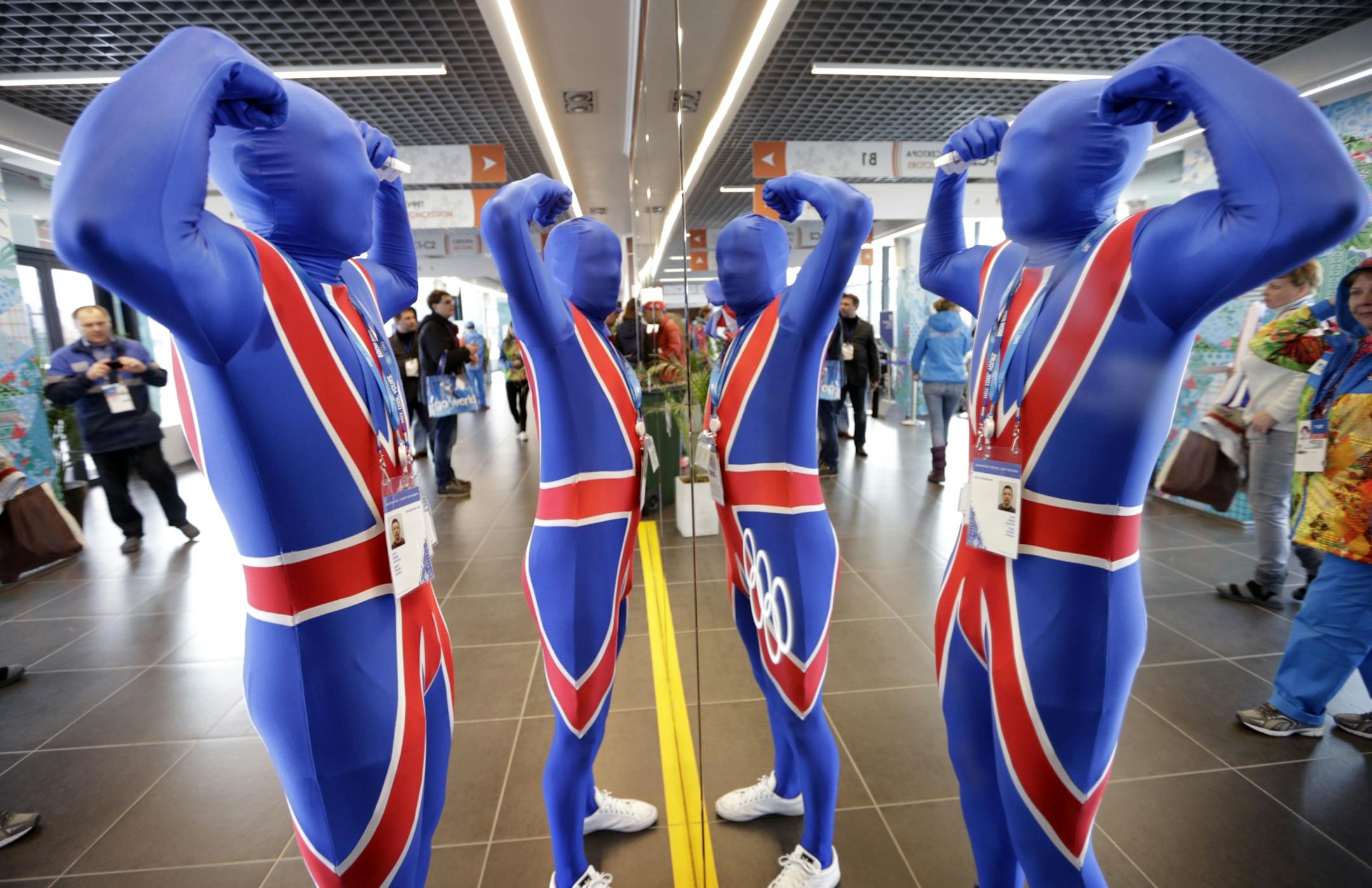 Scott Philip and Robin Dyet of Scotland flex their muscles in a mirror at the Ice Cube Curling Center prior to curling competition between Britain and China during men's against at the 2014 Winter Olympics, Monday, Feb. 17, 2014, in Sochi, Russia.