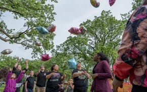 K.G Wilson, right, watches as family and friends release balloons for his granddaughter Aniya Allen at her gravesite at Lakewood Cemetery in Minneapol