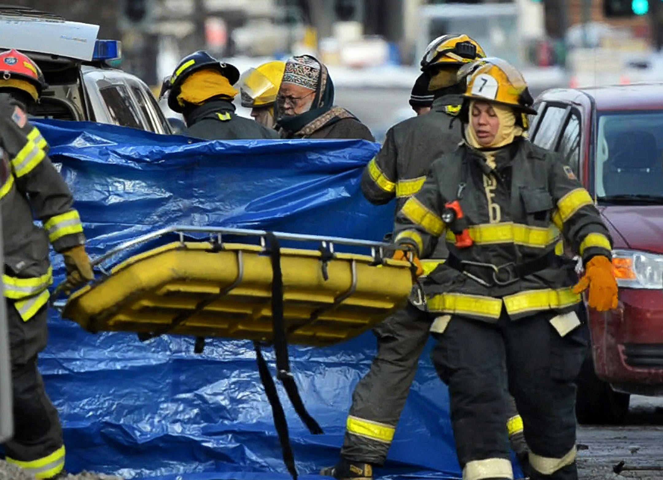 On Friday morning, Jan. 3, 2014, a second body was uncovered from the rubble of the West Bank building that burned New Year's Day. Imam Sheikh Saad Musse Roble (center) presides over the body as it's moved. ] DAVID BREWSTER/STAR TRIBUNE ORG XMIT: MIN1401031138480974