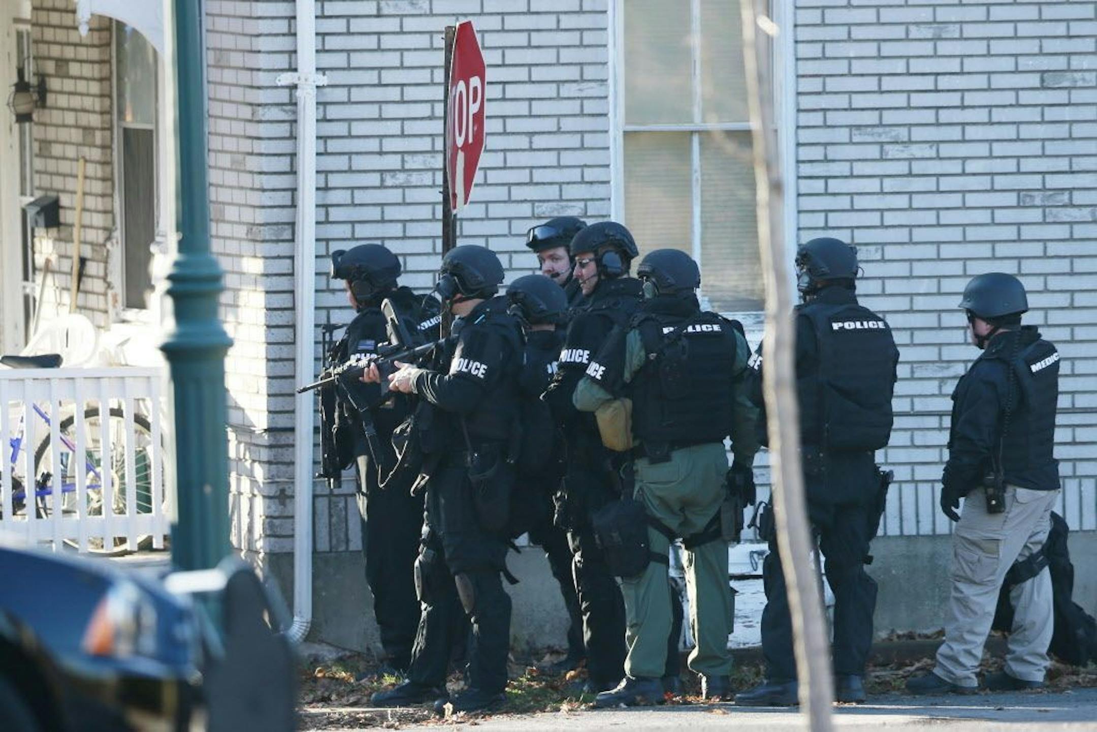 Police gather near a home, Monday, Dec. 15, 2014, in Pennsburg, Pa., where suspect Bradley William Stone was believed to have barricaded himself inside after shootings at multiple homes.