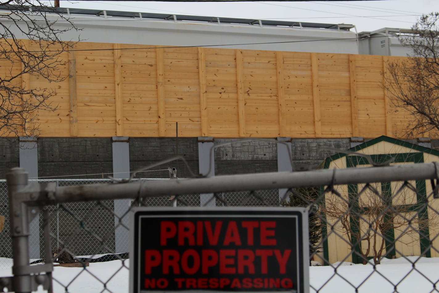 A new retaining wall and five-foot wooden sound barrier have been erected in place of trees in Northeast Minneapolis