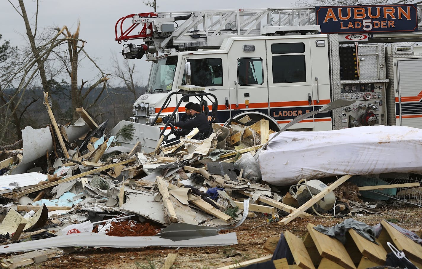 Rescue workers in a four wheeler pass by the wreckage of a home along Lee Road 38 after a Sunday night tornado on Monday, March 4, 2019, in Beauregard, Ala.