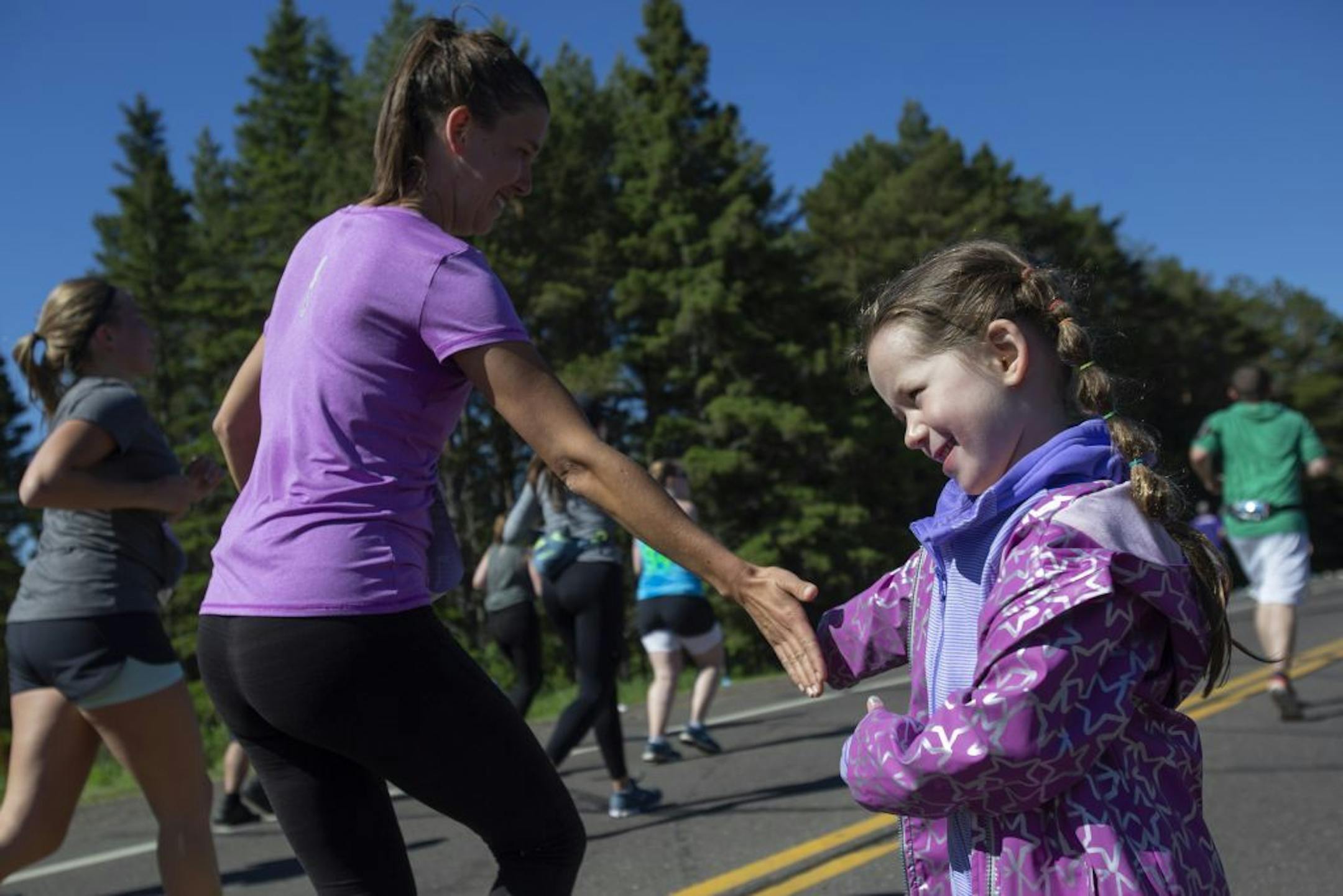 Drew Tollefson, 5, leaves her hand out for runners to high-five during Grandma's Marathon at the nine mile marker.