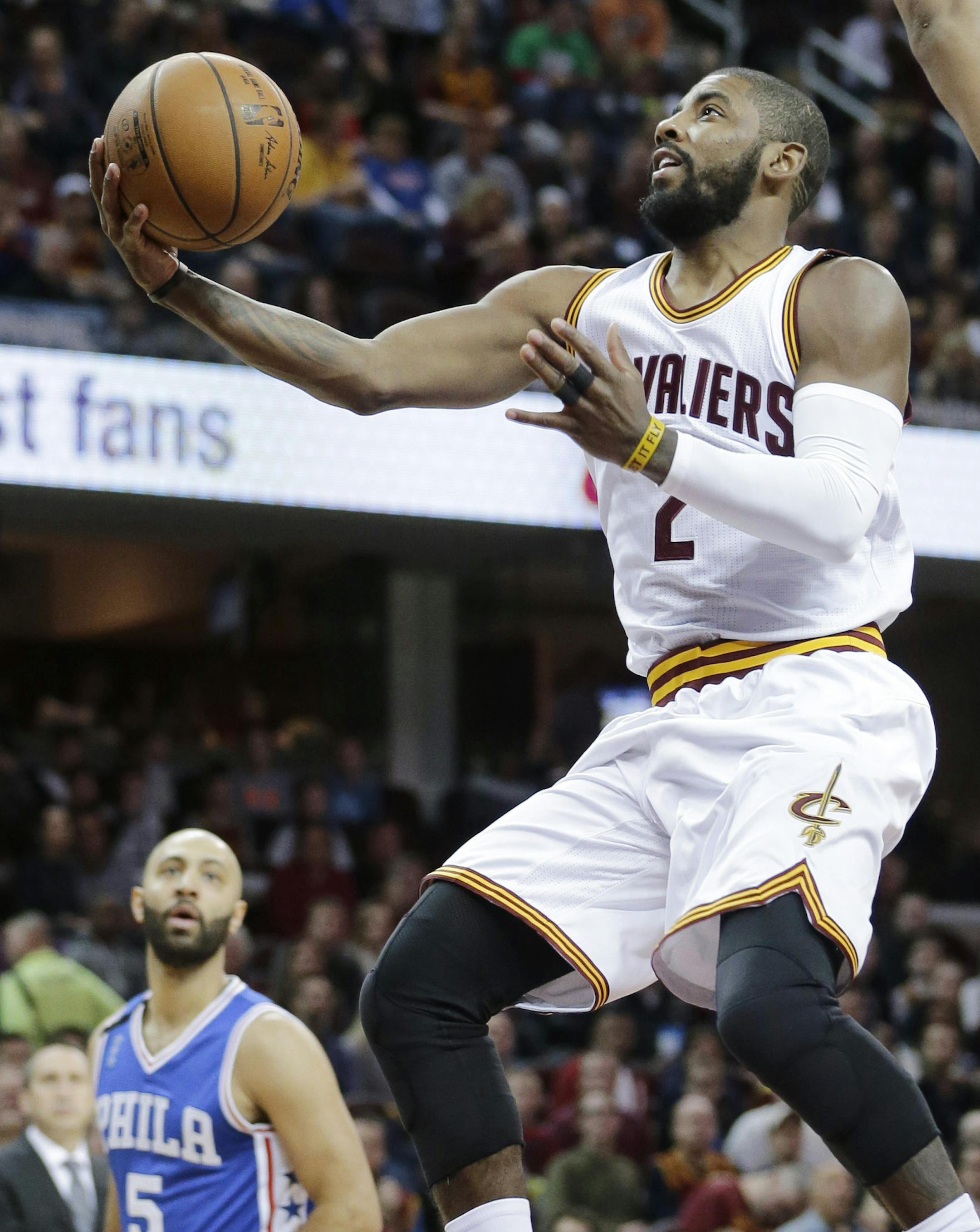Cleveland Cavaliers' Kyrie Irving (2) drives to the basket against Philadelphia 76ers Jahlil Okafor (8) in the first half of an NBA basketball game, Sunday, Dec. 20, 2015, in Cleveland. (AP Photo/Tony Dejak)