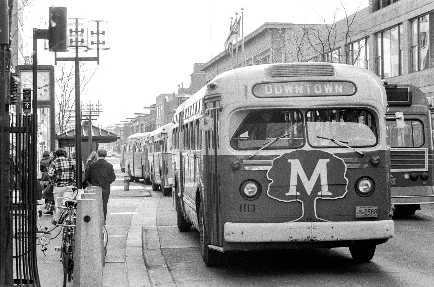 A caravan of buses line up on Nicollet Avenue. (Note the bus ad for defunct Midwest Federal.)