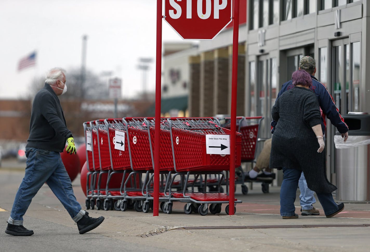 Grocery carts set up a path for shoppers at the entrance to a Target store Monday, April 6, 2020, in Bloomington, Minn., where an employee keeps count of customers as the number allowed in is limited to help reduce the spread of the coronavirus. The new coronavirus causes mild or moderate symptoms for most people, but for some, especially older adults and people with existing health problems, it can cause more severe illness or death. (AP Photo/Jim Mone)