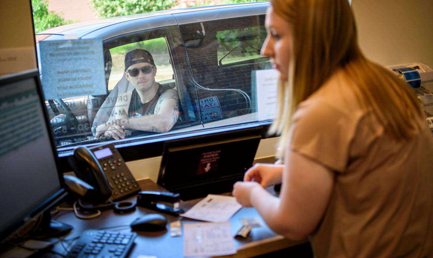 Miranda Sylvander helped Jacob Leverenz get a new set of vehicle license plates and tabs at the Carver County Service Center in Chanhassen. ] GLEN STUBBE * gstubbe@startribune.com Monday, August 22, 2016 Driv-thru service centers are popping up in the suburbs as a way to shortern wait time and ease up conjestion for tab renewals.