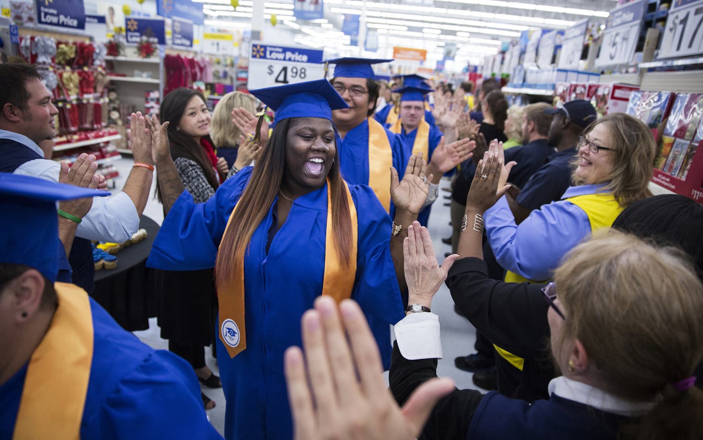 Walmart Academy graduate Jessica Hall, center, processes down the aisle of Walmart with fellow graduates to attend their ceremony. ] (Leila Navidi/Star Tribune) leila.navidi@startribune.com BACKGROUND INFORMATION: The graduation ceremony for Walmart Academy at the Walmart Supercenter in Maple Grove on Tuesday, October 18, 2016. The Maple Grove Walmart Academy is the 15th to open in the U.S.