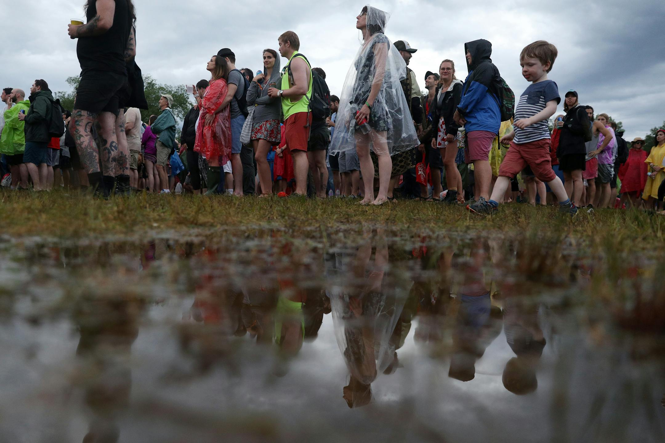 Festival goers dodged puddles as they listened to Paul Simon perform after a brief rain delay.