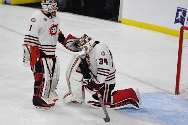 Jeff Smith (1) consoled fellow St. Cloud State goalie David Hrenak (34) in Friday's NCAA men's hockey tournament West Regional semifinal in Sioux Fall