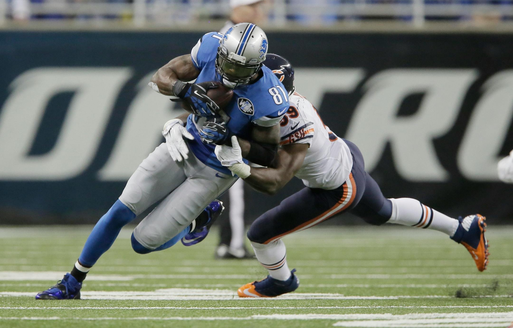 Detroit Lions wide receiver Calvin Johnson (81) is tackled by Chicago Bears inside linebacker Christian Jones (59) after his 9-yard reception during the first half of an NFL football game in Detroit, Thursday, Nov. 27, 2014. With this catch, Johnson set a new NFL record for fewest games (115) to reach 10,000 career receiving yards. (AP Photo/Duane Burleson)