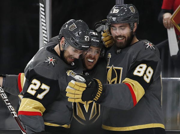 Vegas Golden Knights defenseman Shea Theodore (27), center Jonathan Marchessault, center, and right wing Alex Tuch (89) celebrate Tuch's goal against 