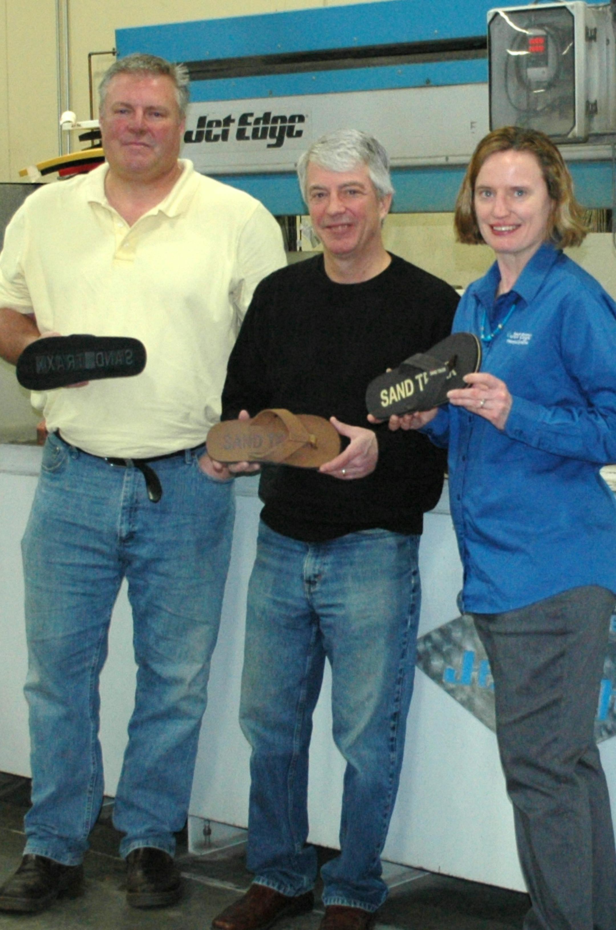 Sand Traxx sandals created by Waconia sod farmer, Jeffrey Wagener, with the help of Jet Edge Inc. President Jude Lague. Jet Edge is based in St. Michael, Mn. In this photo (l-r) Jeff Wagener, Jude Lague, Nancy Lauseng.