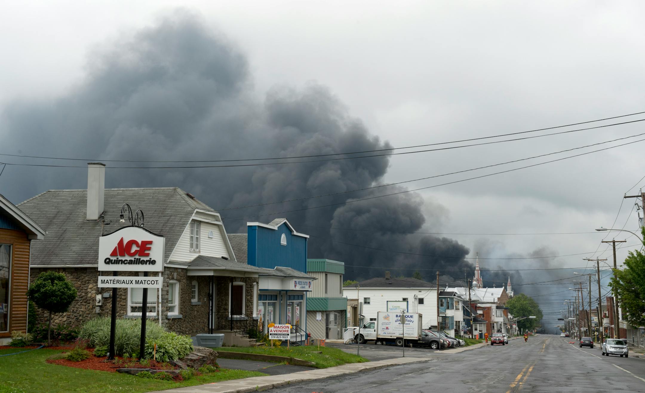Smoke rises from railway cars that were carrying crude oil after derailing in downtown Lac Megantic, Quebec, Canada, Saturday, July 6, 2013. The derailment sparked several explosions and forced the evacuation of up to 1,000 people. (AP Photo/The Canadian Press, Paul Chiasson)
