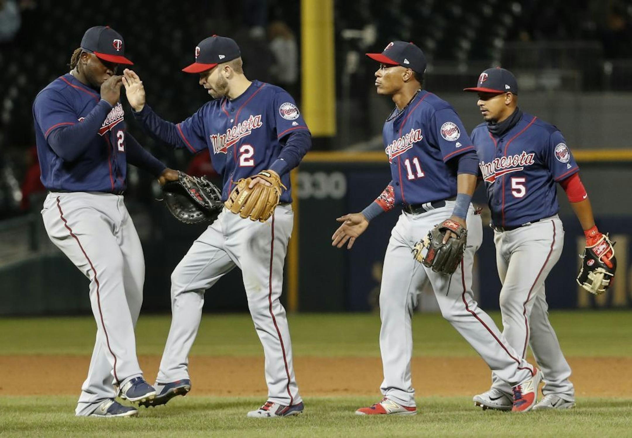 Minnesota Twins third baseman Miguel Sano, left, celebrates with second baseman Brian Dozier, second left, after their win over the Chicago White Sox on April 7.
