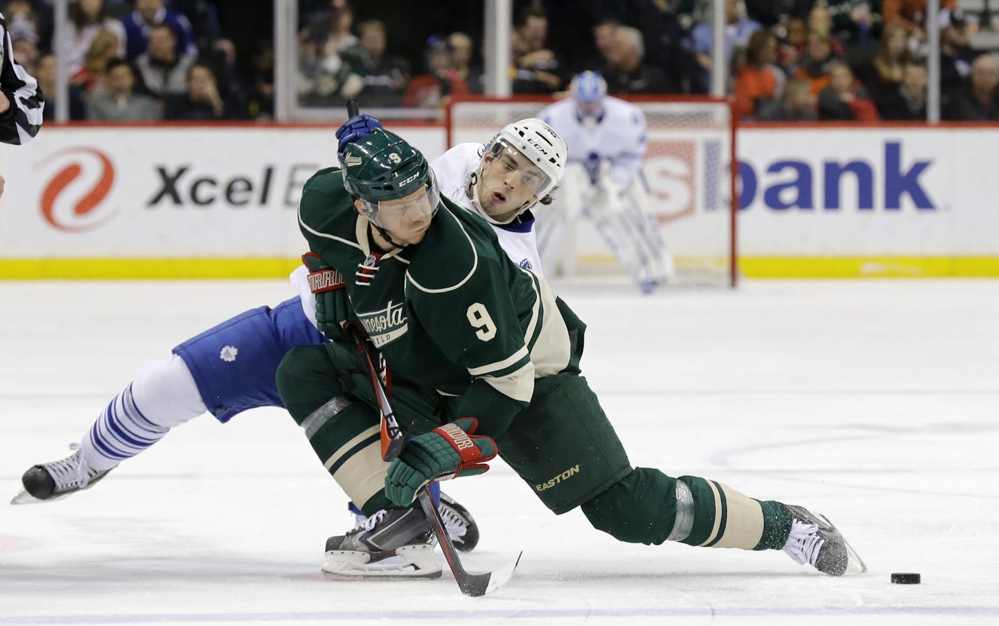 Minnesota Wild center Mikko Koivu (9), of Finland, and Toronto Maple Leafs center Gregg McKegg (36) tangle after a face-off during the second period of an NHL hockey game in St. Paul, Minn., Friday, Jan. 2, 2015. (AP Photo/Ann Heisenfelt)