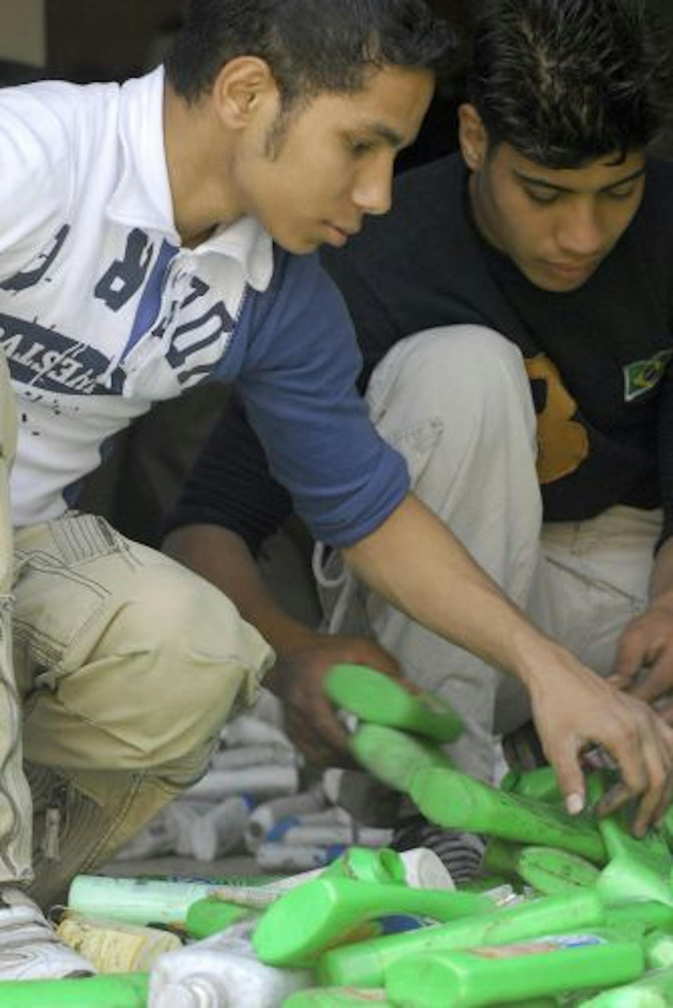 Egyptian teens Adham and Nabil sort shampoo bottles in the documentary �Garbage Dreams,� which opens the Twin Cities Arab Film Festival Thursday at the Heights. Credit: Iskander Films