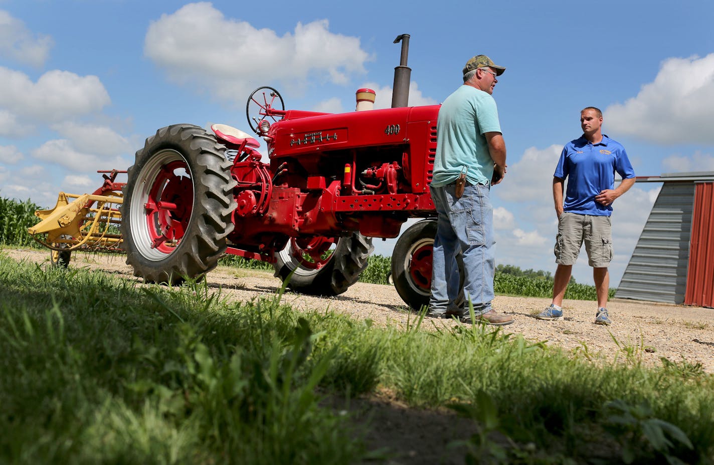 Farmer Jim York, left, and local auto painter Kevin Kolander stand next to the York family's International Harvester Farmall 400 tractor, similar to the one that was donated to a small village in Burkina Faso and was seen Wednesday, June 29, 2016, in Lake Wilson, MN. Kolander and his company donated the work hours in restoring the exterior and painting the tractor that was donated to a village in Africa.](DAVID JOLES/STARTRIBUNE)djoles@startribune A bright red tractor donated by farmers in rural