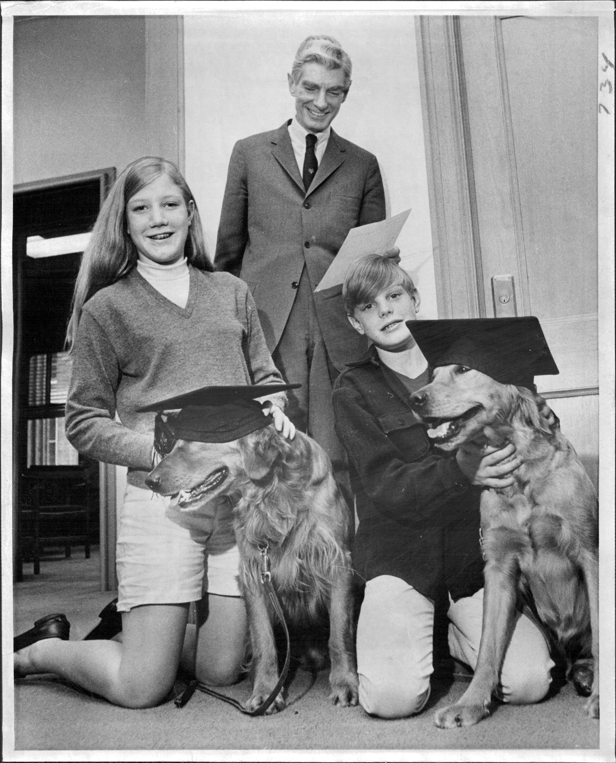 June 20, 1968: University President Malcom Moos read his commencement address at Eastcliff with daughter Kathy and son Grant and their golden retrievers who'd just graduated from canine college.