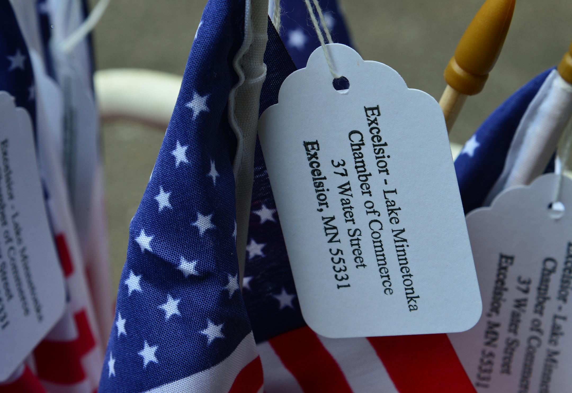 Martie McGlasson of Tonka Bay leaves her house to go door-to-door fundraising for Lake Minnetonka's annual Fourth of July celebration. Carrying a bucket of flags, McGlasson is going around asking residents to help support the largely free event that is mostly supported by donations. When she can't speak directly to residents she will leave a flag with donation information on a tag. ]Richard.Sennott@startribune.com Richard Sennott/Star Tribune Tonka Bay Minn.Wednesday 6/25/2014) ** (cq) ORG XMIT: