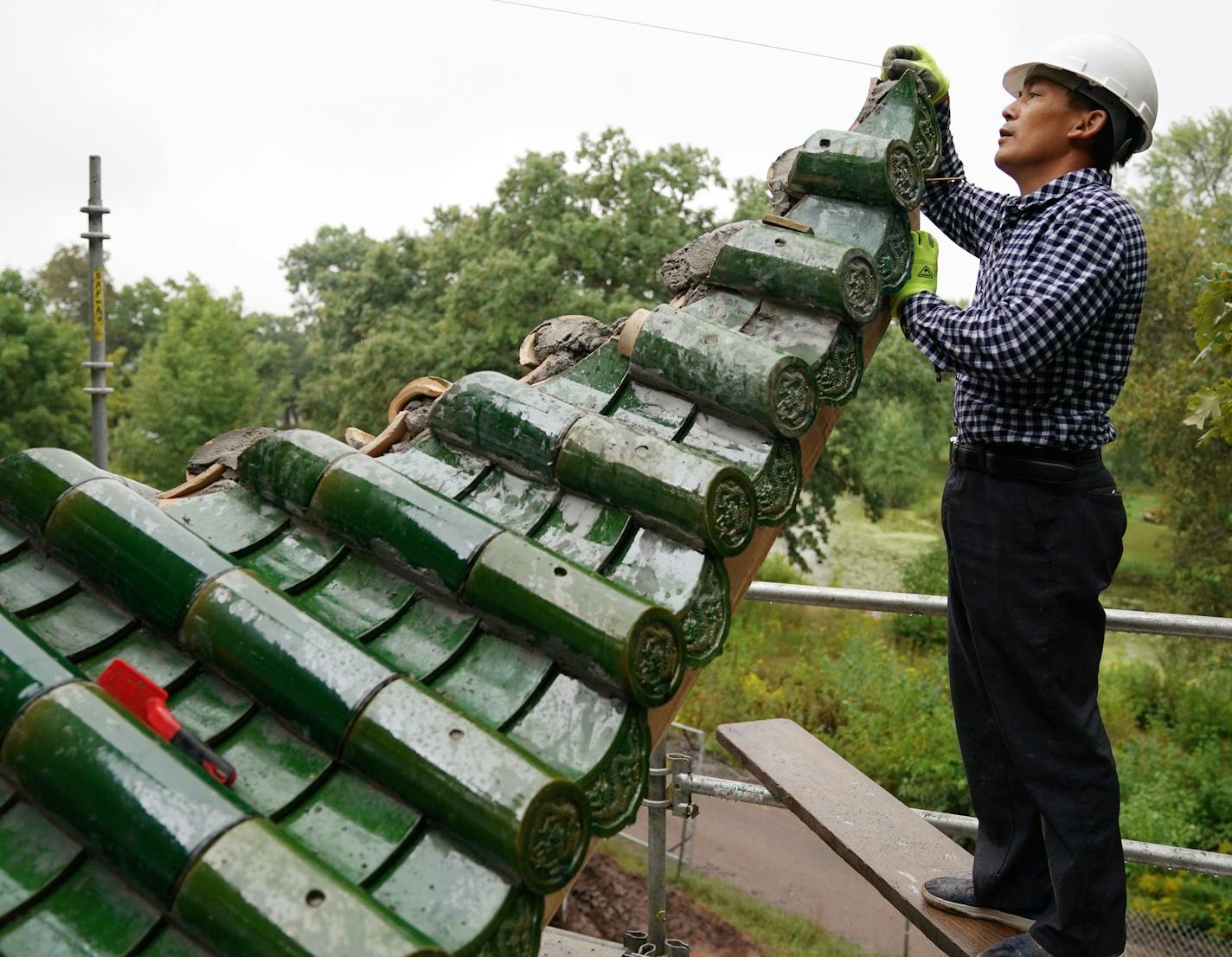 Lou Han Ming worked from scaffolding on the second story of the Chinese pavilion. ] ANTHONY SOUFFLE &#x2022; anthony.souffle@startribune.com Workers continued on construction of a Chinese pavilion, along with a Chinese friendship garden, along the shore of Lake Phalen Tuesday, Aug. 28, 2018 in St. Paul, Minn. The pavilion, a replica of the Aiwan Pavilion in Changsha, China, a St. Paul sister city, was built in China, then deconstructed and shipped to the U.S. for assembly here.