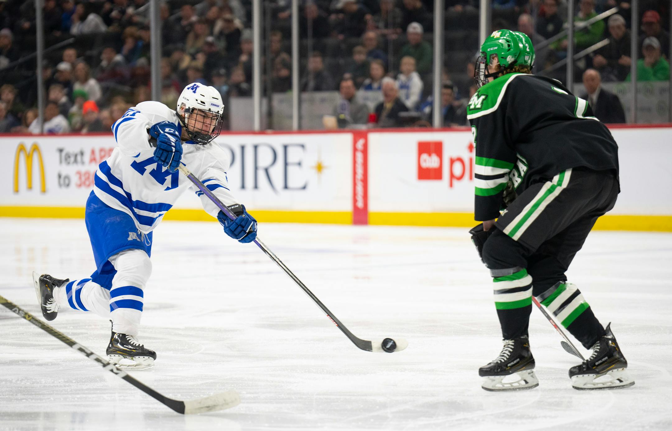Minnetonka Skippers forward Sam Scheetz (21) shot on goal while Hill-Murray Pioneers defenseman Joseph Luger (2) defended in the first period.