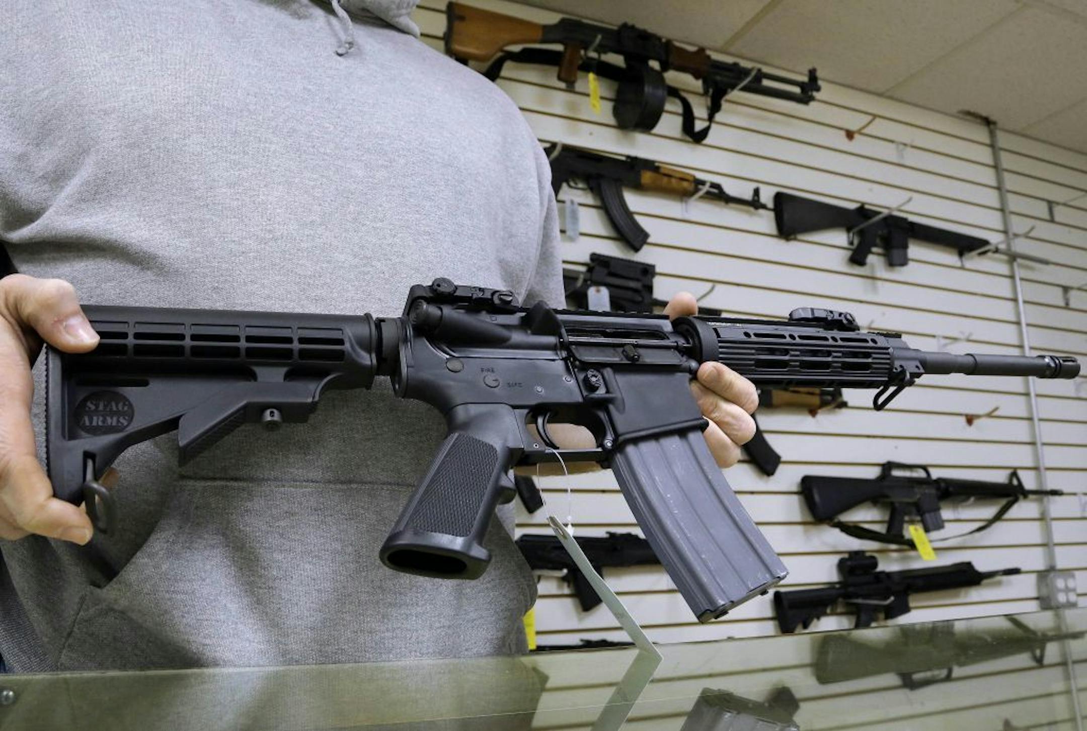 John Jackson, co-owner of Capitol City Arms Supply in Springfield, Ill., shows off an AR-15.