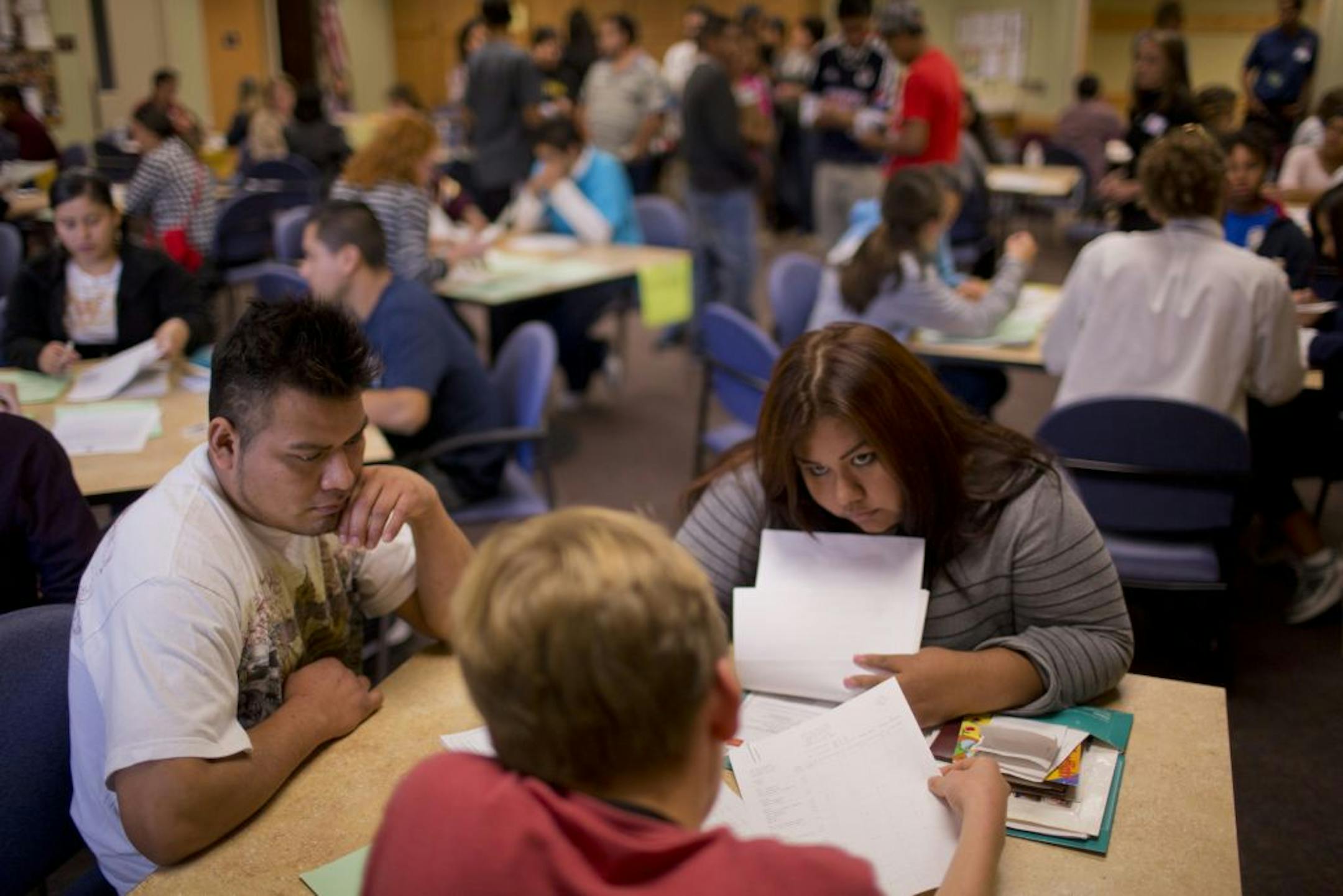 Ana Lara, 23, organized her documents with volunteer Robbie Emmett at an Immigrant Law Center workshop Wednesday in Northfield. With her was Alfredo Calmo.