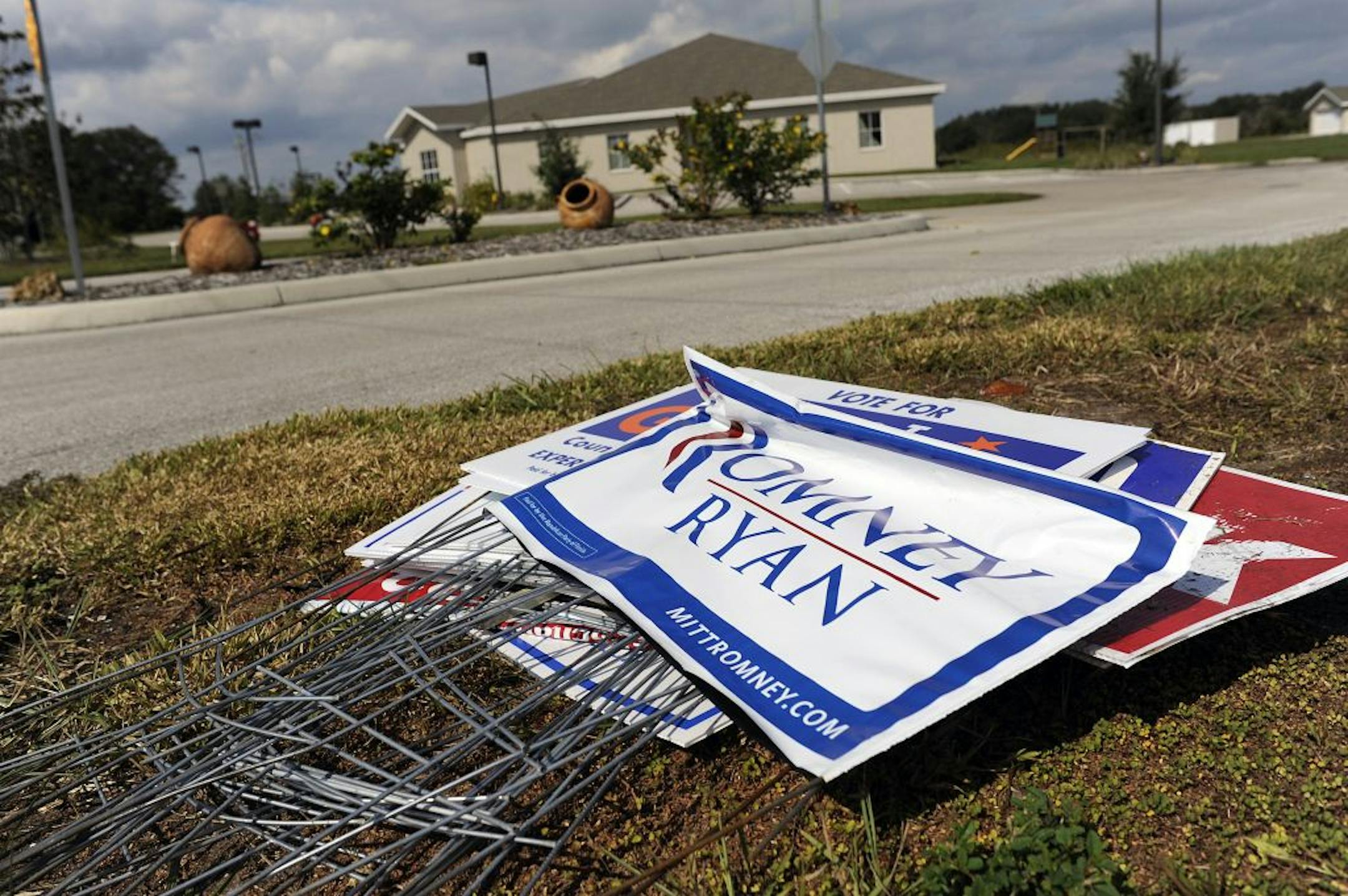 Campaign signs, including some for Mitt Romney, sit in a pile at the curb in front of a polling station in Bradenton, Fla., Nov. 7, 2012. Just as in the 2000 presidential election, the results of Florida's voting were still up in the air the day after Election Day.