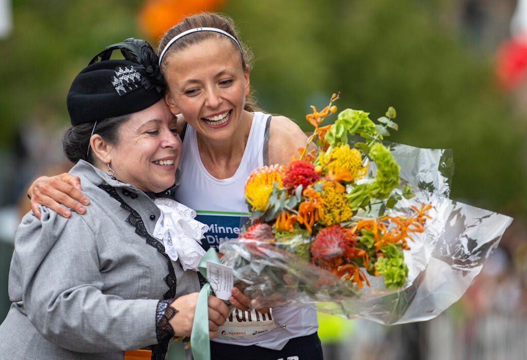 Dakotah Lindwurm received flowers from the official Grandma, played by Leah Hulst, at the finish line of Grandma's Marathon in 2021.